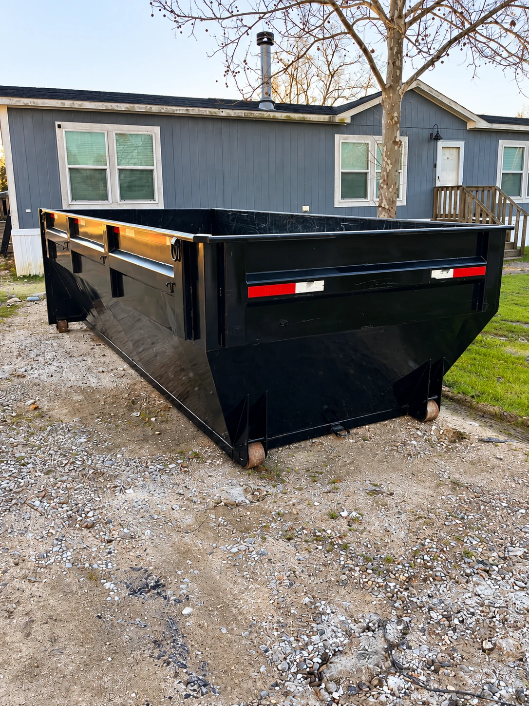 Gonzalez Services black roll-off container at a property