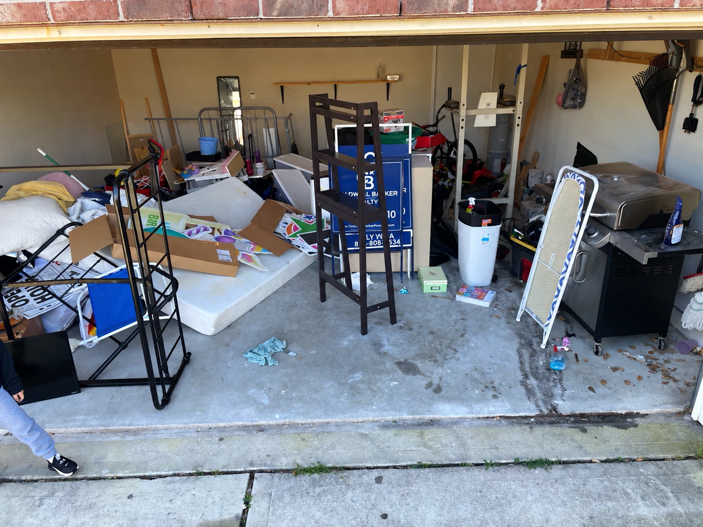 Household items and furniture awaiting removal in a garage